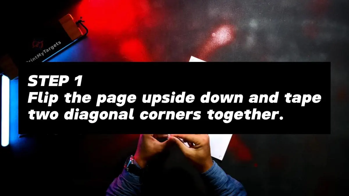 Step 1 - Flip the page upside down and tape the two diagonal corners together.