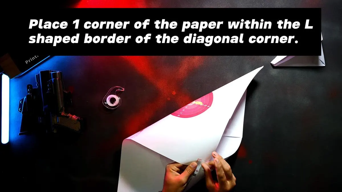 Place 1 corner of the paper within the L shaped border of the diagonal corner.